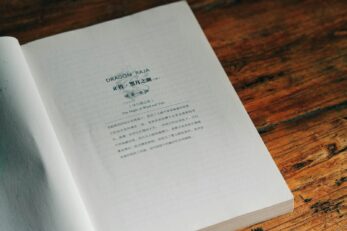 Photo by 8 verthing An open book sitting on top of a wooden table